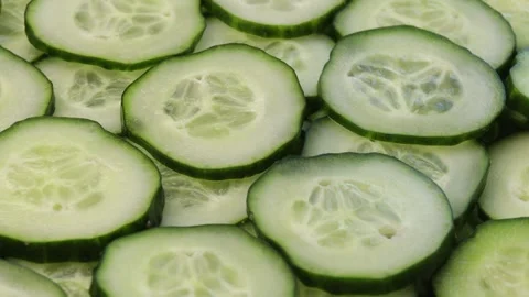 Fresh cucumber slices rotating in a circular motion. Green cucumber pieces Stock Footage 304682777