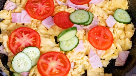 Fresh cucumbers falling on omelette in slow motion Stock Footage 91103121
