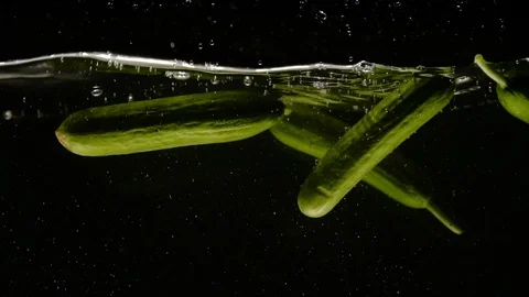 Fresh Cucumbers falling into water  close-up slow motion Video stock 91496850
