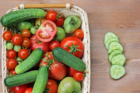Fresh cucumbers, red and green tomatoes  in a basket Stock Photos