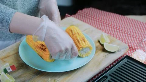 Fresh culinary study: arranging grilled corn on a plate Stock Photos