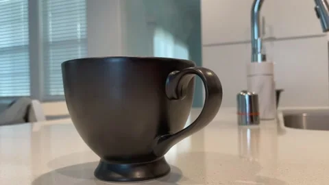 A fresh cup of coffee on a white kitchen countertop. Hot steam rising from 스톡 동영상 149105945
