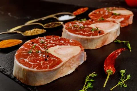 Fresh cut beef shank in bone and seasonings on black board. Stock Photos