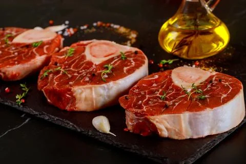 Fresh cut beef shank in bone and seasonings on black board. Stock Photos