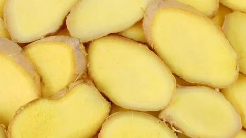 Fresh cut ginger root slices circle rotation close up top view Stock Footage 274437972