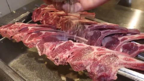 Fresh Cut Raw Lamb Chops Being Seasoned in a Kitchen Sink 스톡 동영상 332812759