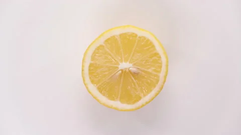 Fresh cutted yellow lemon spin on white background top down view. Freshly picked Stock Footage 148514113