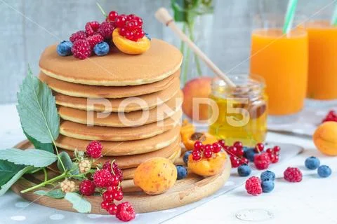 Fresh delicious pancakes with summer berries on light surface Stock Photos