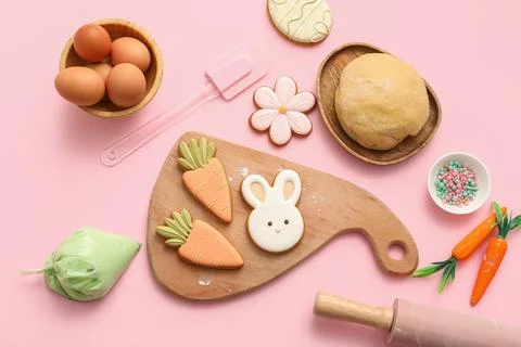 Fresh dough with Easter cookies, eggs, piping bag and kitchen utensils on pin Stock Photos