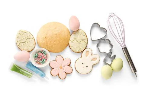 Fresh dough with Easter cookies, eggs, icing tubes and kitchen utensils on wh Stock Photos