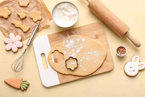 Fresh dough with raw Easter cookies, flour, sprinkles and kitchen utensils on Stock Photos