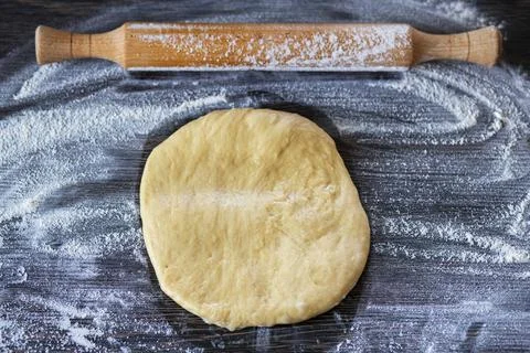 Fresh dough ready to bake. Bread dough on wooden kitchen counter with rolling Stock Photos