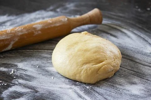 Fresh dough ready to bake. Bread dough on wooden kitchen counter with rolling Foto stock