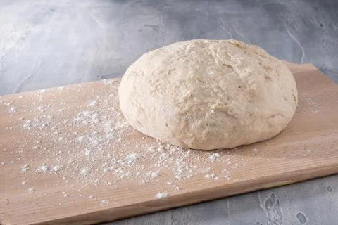 Fresh dough ready for baking bread or pizza on wooden board. Stock Photos