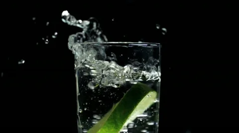 Fresh drink super slow motion high speed lemon splashing into glass of water Stock Footage 22101509