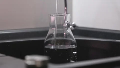 Fresh drinking water pouring from kitchen tap into reusable bottle Stock Footage 339794812