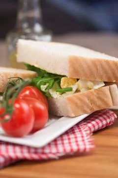 Fresh egg and rocket on white sandwich in rustic kitchen setting Stock Photos