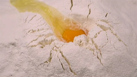 Fresh egg falling in white flour in slow motion Stock Footage 81180658