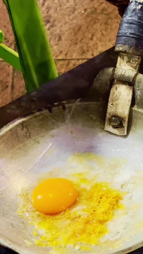 Fresh egg mixture cooks in a metal pan over charcoal during traditional Ind.. Stock Footage 340116018
