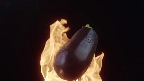 Fresh eggplant is spinning in circles in flames. 4K slow motion video Stock Footage 168816117