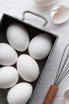 Fresh eggs, eggshells and whisk for whipping Foto stock