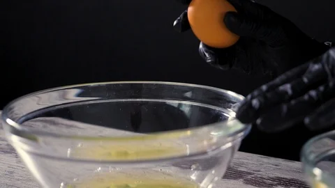 Fresh eggs falling into bowl. Egg yolk falling in glass bowl. Separating the Stock Footage 86534322
