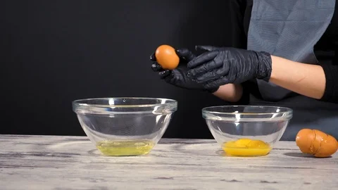 Fresh eggs falling into bowl. Egg yolk falling in glass bowl. Separating the Stock Footage 86534357