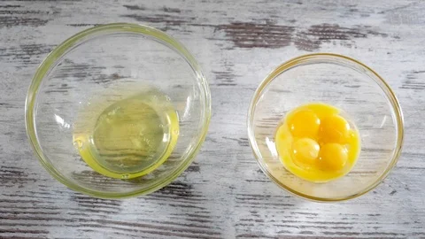 Fresh eggs falling into bowl. Egg yolk falling in glass bowl. Separating the Stock Footage 86534393