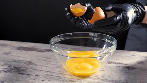 Fresh eggs falling into bowl. Egg yolk falling in glass bowl. Separating the Stock Footage 86534408