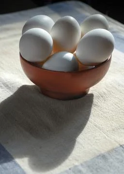Fresh the eggs on the kitchen table. Just assembled in the house. The rays of Stock Photos