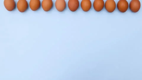 Fresh eggs move in one line on top of blue theme. Stop motion Stock Footage 149321541