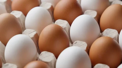 Fresh eggs nestled in delicate paper tray. Rotating white and brown eggs Stock Footage 304550894
