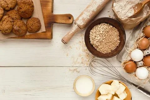 Fresh eggs, oats, and bread on a rustic kitchen table Stock Photos
