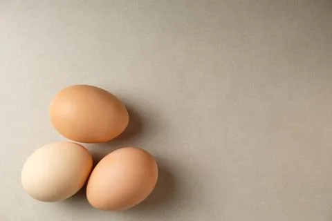 Fresh eggs resting on a smooth surface add warmth to the kitchen setting Stock Photos