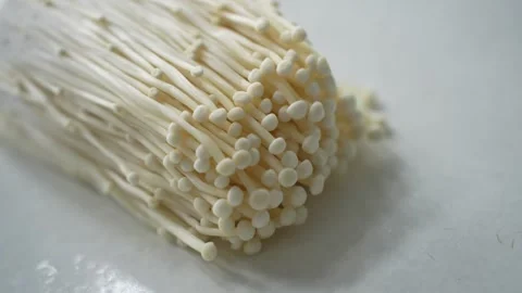Fresh enoki mushrooms on a white surface Stock Footage 339061092