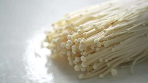 Fresh enoki mushrooms on a white surface Stock Footage 339061252