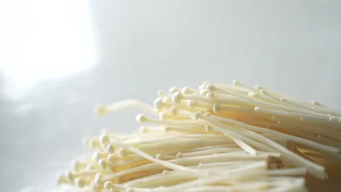 Fresh enoki mushrooms on a white surface Stock Footage 339061518