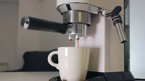 Fresh Espresso Pouring from a Coffee Machine into a White Cup in a Home Kitchen Stock Footage 302172807