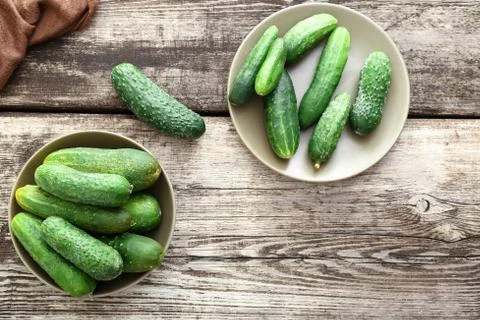 Fresh farm cucumbers in rustic plates on a wooden background, copy space. Fla Stock Photos