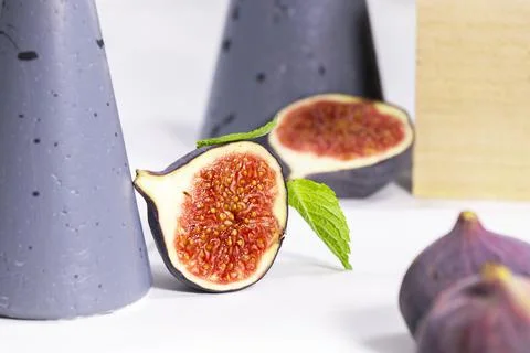 Fresh Fig with mint leaf on gray stands and podiums over white background Stock Photos
