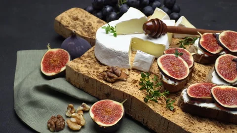 Fresh fig slice with cheese on wooden cutting board. Slow motion Stock Footage