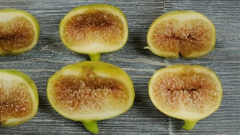 Fresh figs cut in half on a table. Overhead slider shot. Stock Footage 113772363
