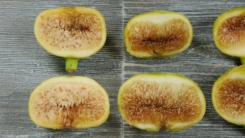 Fresh figs cut in half on a table. Overhead slider shot. Stock Footage 113772620