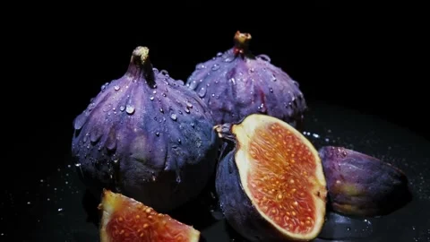 Fresh figs with dew drops close-up rotates on black background Stock Footage 142559468