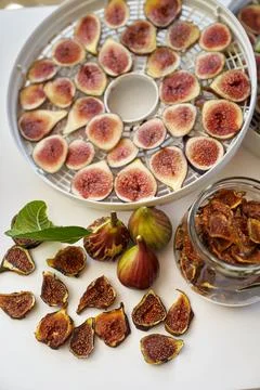 Fresh figs lie on the table next to dried figs in a glass jar. Top view Stock Photos
