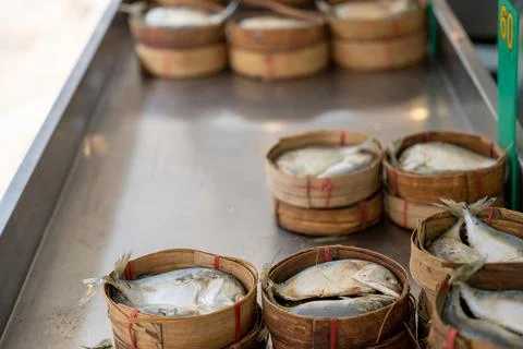 Fresh fish baskets displayed along seafood stall Bangkok market Stock Photos