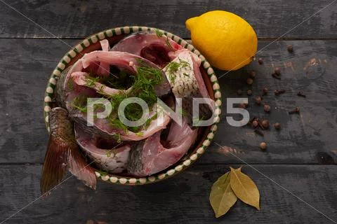 Fresh fish pieces in a bowl with spices and lemon Stock Photos
