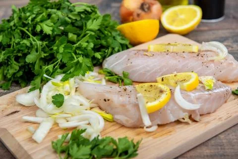 Fresh fish, raw cod fillets with addition of herbs and lemon Stock Photos
