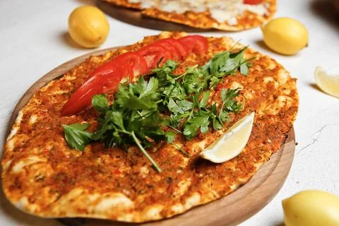 Fresh flatbread with vegetables and herbs served on wooden board Stock Photos