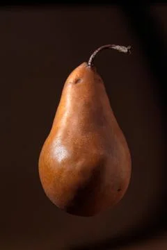 Fresh floating single pear on brown background Stock Photos